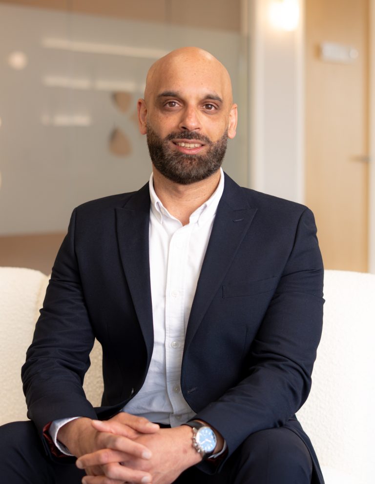 Amit Shingdia, Financial Adviser at Eight Financial Advice, sitting in a cream armchair at the Whiteley office